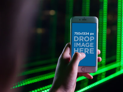 Woman Playing with her iPhone Mockup in a Room with Green Lights