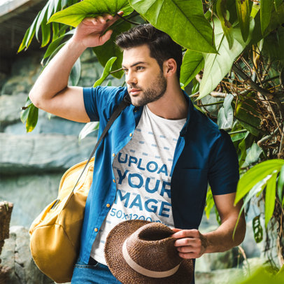 Heather T-Shirt Mockup Featuring a Serious Bearded Man Standing by Tropical Plants 