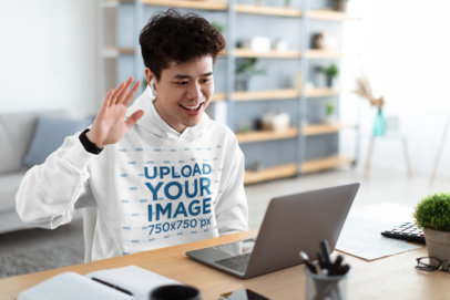 Pullover Hoodie Mockup of a Smiling Man Having a Conference Call on His Laptop