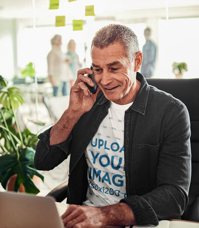 T-Shirt Mockup Featuring an Elderly Man Talking on the Phone at an Office