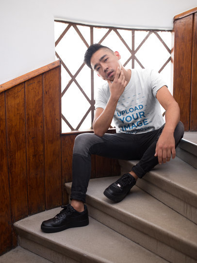 Asian Dude Wearing a Round Neck T-Shirt Mockup while Posing Sitting on Stairways
