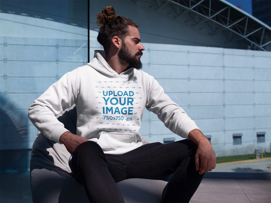 Man Wearing a Pullover Hoodie Mockup Near a Building