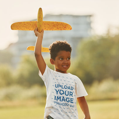 T-Shirt Mockup of a Little Boy Playing a Toy Plane