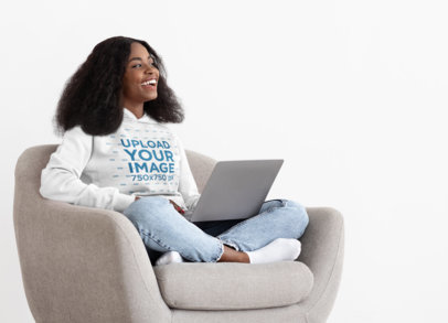Hoodie Mockup of a Woman with Natural Hair Sitting with Her Laptop on an Armchair