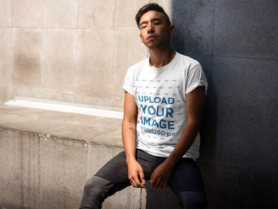 Asian Dude Wearing a Round Neck Tee Mockup While Sitting Against a Wall