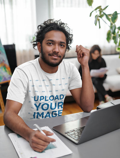 T-Shirt Mockup Featuring a Designer Working From Home