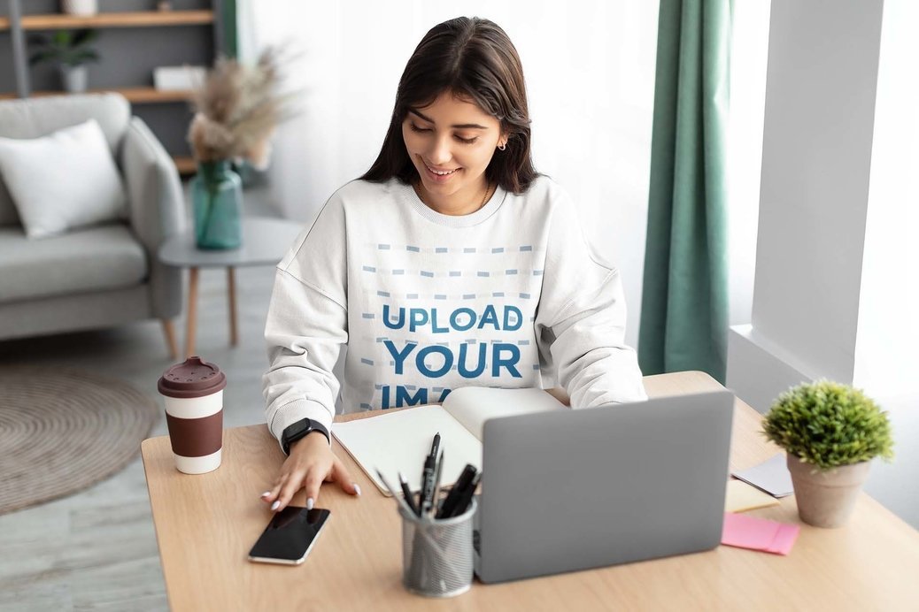 Oversized Sweatshirt Mockup of a Woman Using Her Laptop at Home