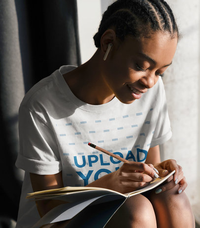 Basic T-Shirt Mockup Featuring a Happy Young Woman Writing 