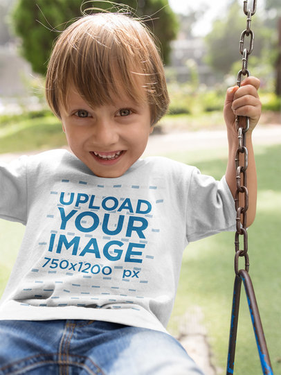 Little Boy Wearing a T-Shirt Mockup While on a Swing