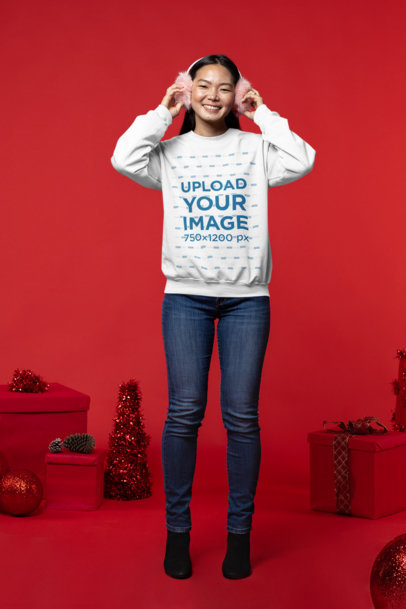 Xmas-Themed Mockup of a Happy Woman Wearing Earmuffs and a Sweatshirt
