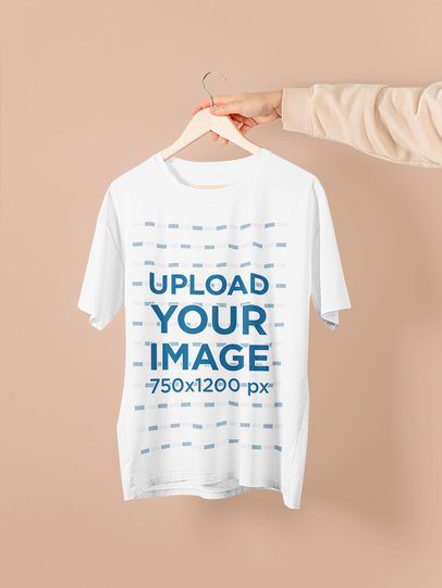 Mockup of Someone Holding a T-Shirt on a Hanger