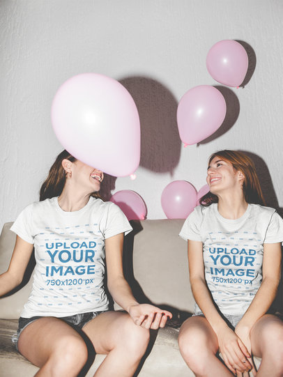 Two Girls Wearing Round Neck Tees Mockup while Sitting in a Sofa with Balloons a17964