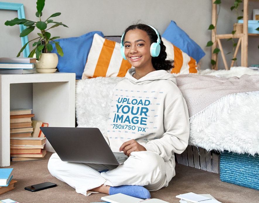 Hoodie Mockup Featuring a Happy Young Woman Listening to Music While Studying