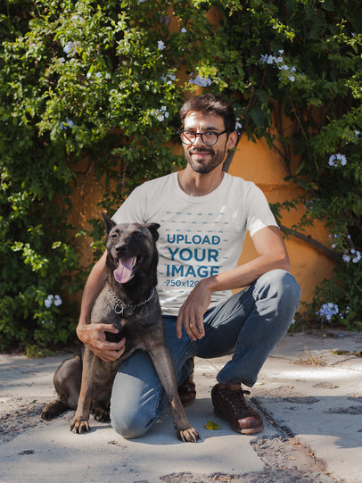 Man with Glasses Wearing a T-Shirt Mockup while with his Dog a17891