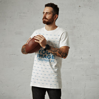 T-Shirt Mockup of a Tattooed Bearded Man Holding a Football