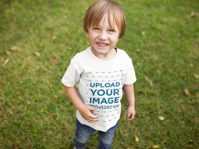 Happy Blonde Boy Wearing a Tshirt Mockup at the Park