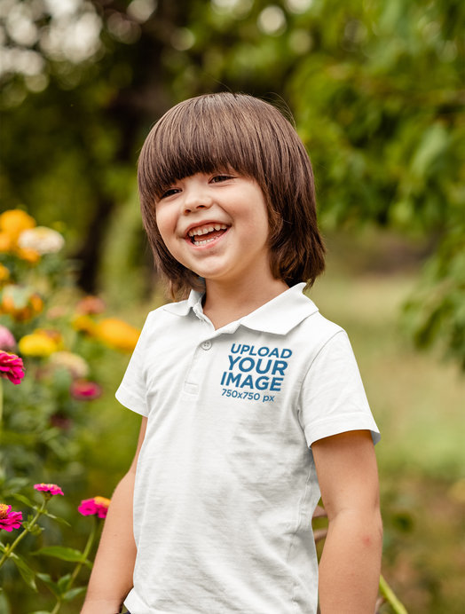 Polo Shirt Mockup of a Happy Kid Posing Beside Some Flowers