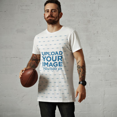 T-Shirt Mockup of a Man with Arm Tattoos Holding a Football