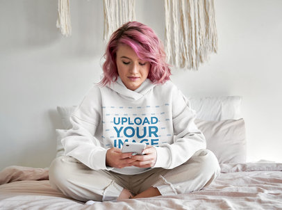 Hoodie Mockup Featuring a Young Woman Texting at Home