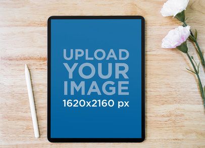 Mockup of an iPad in Portrait Position Placed by Some Flowers