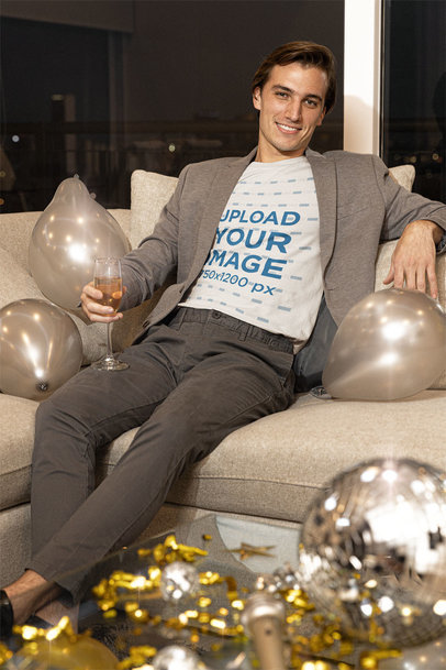 T-Shirt Mockup of a Man Relaxing on a Couch During an NYE Party
