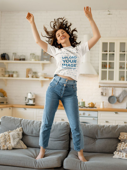 T-Shirt Mockup of a Cheerful Woman Jumping on the Sofa