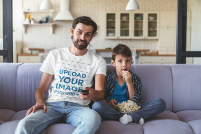 T-Shirt Mockup Featuring a Man Watching Movies with His Son at Home
