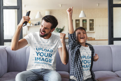 T-Shirt Mockup of a Man and His Son Cheering at Home
