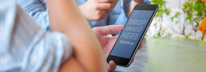 Wide Mockup of Friends Relaxing Holding an iPhone 6