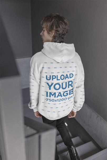 Back-View Mockup of a Man on a Staircase Wearing a Hoodie with Customizable Sleeves