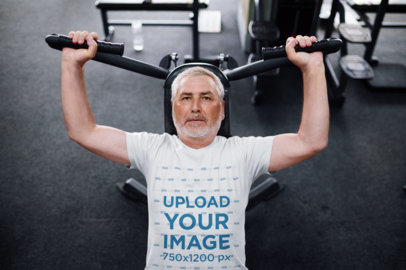 T-Shirt Mockup Featuring an Elderly Man Working Out in a Gym
