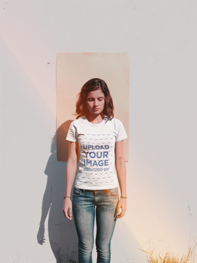 Woman Wearing a Tshirt Mockup Standing Against a Cardboard on a Wall