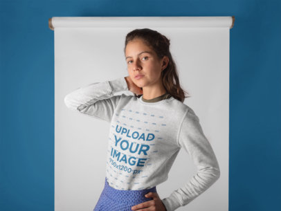 Pretty Woman Posing Wearing a Crewneck Sweatshirt Against a Wall with a White Paper