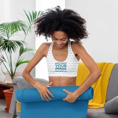 Sublimated Sports Bra Mockup Featuring a Woman with Curly Hair Rolling a Mat
