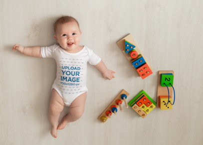 Mockup of a Baby Wearing a Onesie Featuring Some Toys