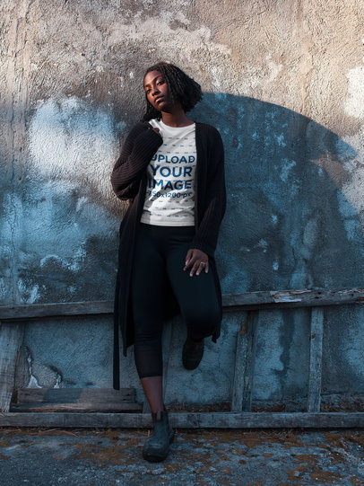 Short Haired Woman Wearing a Round Neck Tee Mockup Lying Against a Concrete Wall