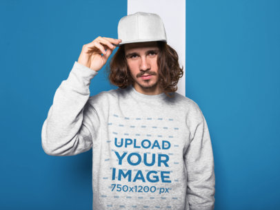 Long Haired Man Holding his Hat Wearing a Crewneck Sweatshirt Mockup