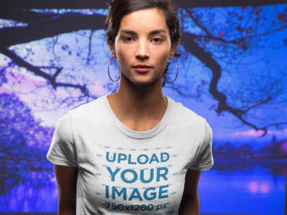 Front Shot of a Beautiful Woman Wearing a T-Shirt Mockup Against a Purple Lake Background 