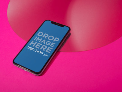 Jet Black iPhone X Mockup Lying Angled on a Magenta Surface a19112