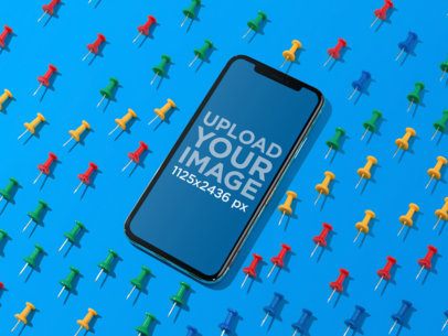 Mockup of a Black iPhone 11 Pro on a Blue Surface Surrounded by Board Pins