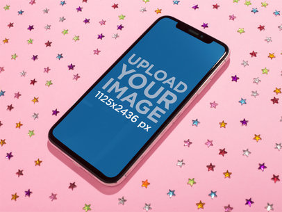 Jet Black iPhone X Mockup Lying on a Pink Surface with Bright Stars Stickers a19122