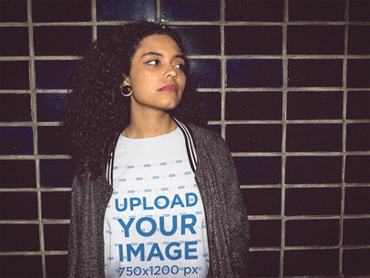 Night Mockup of a Woman Wearing a T-Shirt Against a Black Tiles Wall