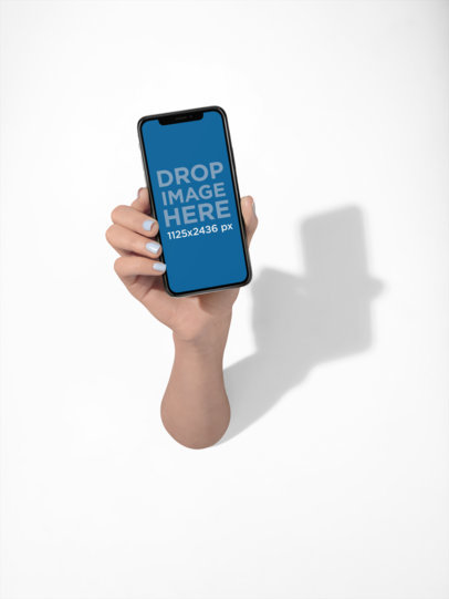 Hand Holding a Black iPhone X Mockup on a Solid Color Surface a19124
