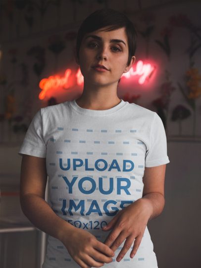 Mockup of a Pretty Woman Wearing a T-Shirt Mockup in a Room with a Neon Sign