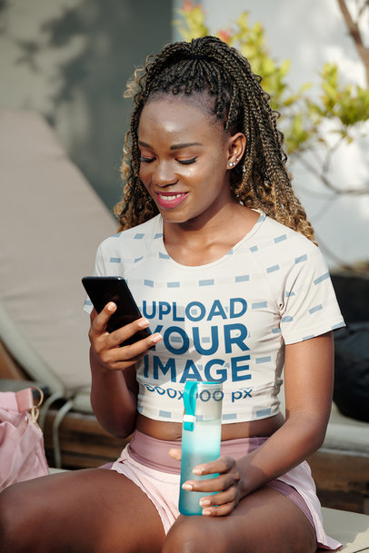 Sublimated Crop Top Mockup of a Happy Woman Checking Her Phone m20718-r-el2