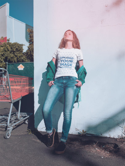 T-Shirt Mockup of a Woman Leaning Against a Wall Outside a Supermarket a18477