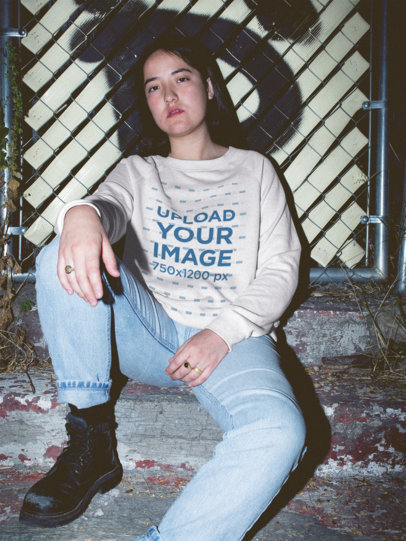 Asian Woman Waiting for a Friend Sitting on the Street Wearing a Crewneck Sweatshirt Mockup a18852