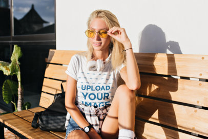 Heathered T-Shirt Mockup of a Blonde Woman Sitting on a Wooden Bench
