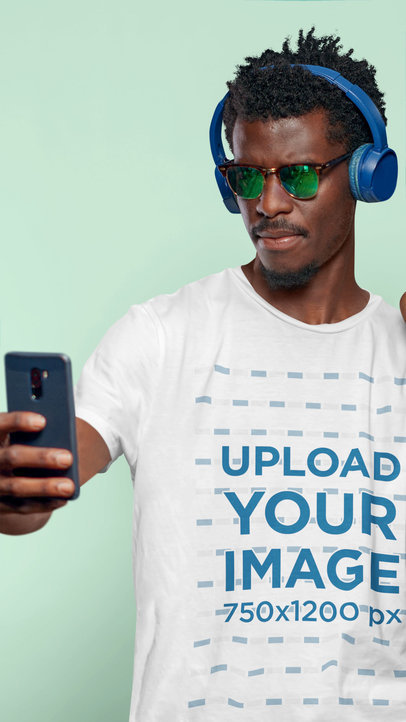 T-Shirt Mockup Featuring a Man with Sunglasses and Headphones Taking a Selfie