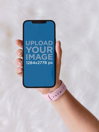 Mockup of a Woman Holding an iPhone 12 Pro Max Against a White Background